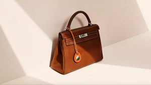 Apple airtag holder brown color hanging with bag.